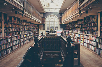 Library with full shelves, downward staircase in the middle of the room